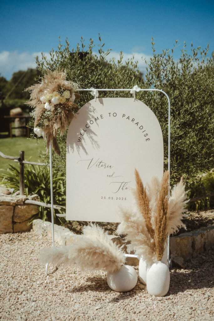 Mallorca Hochzeit. Schöne Dekoration aus Pampasgras und einem Willkommen Schild.