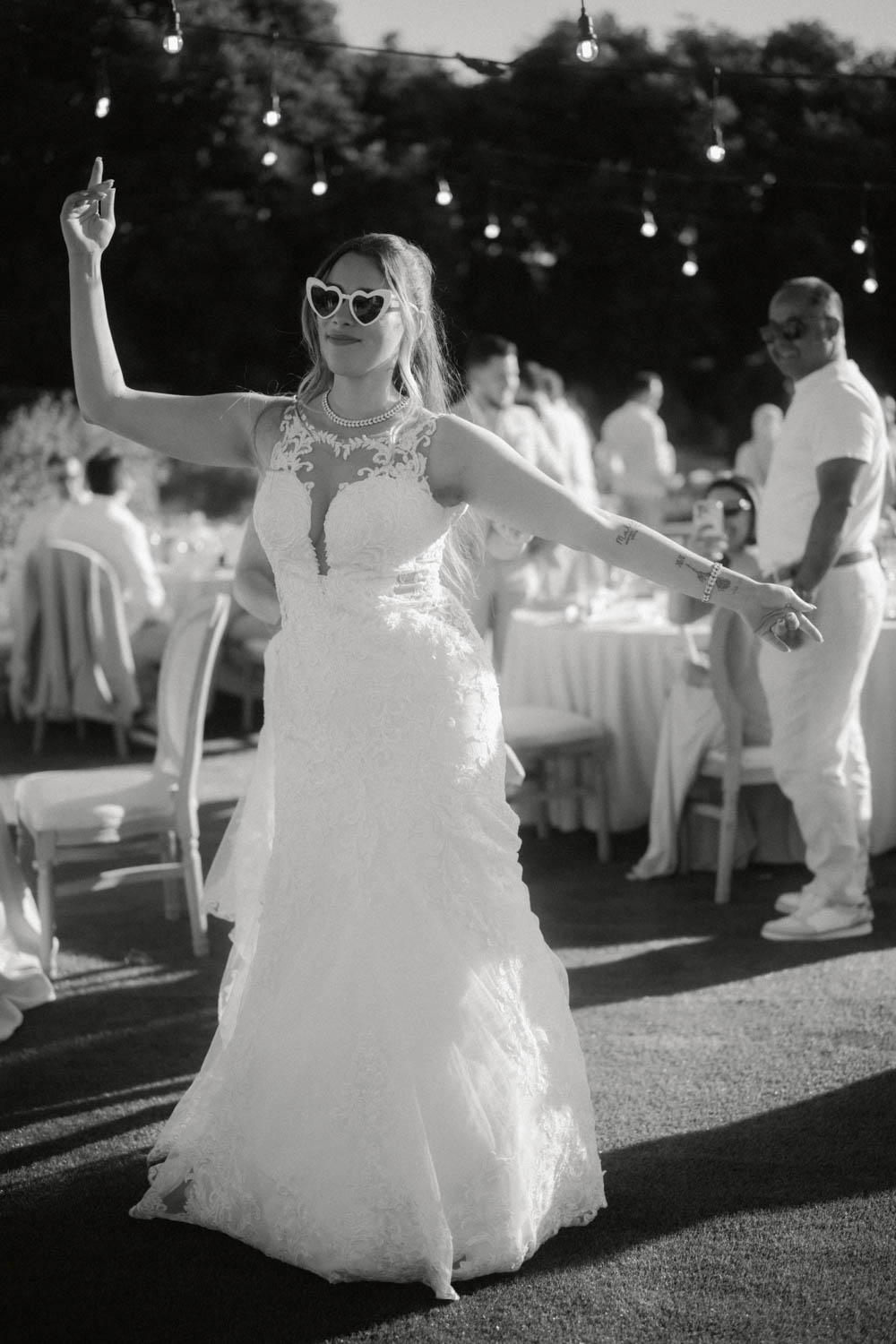 Braut feiert auf ihrer Mallorca Hochzeit und tanzt mit einer Sonnenbrille.
